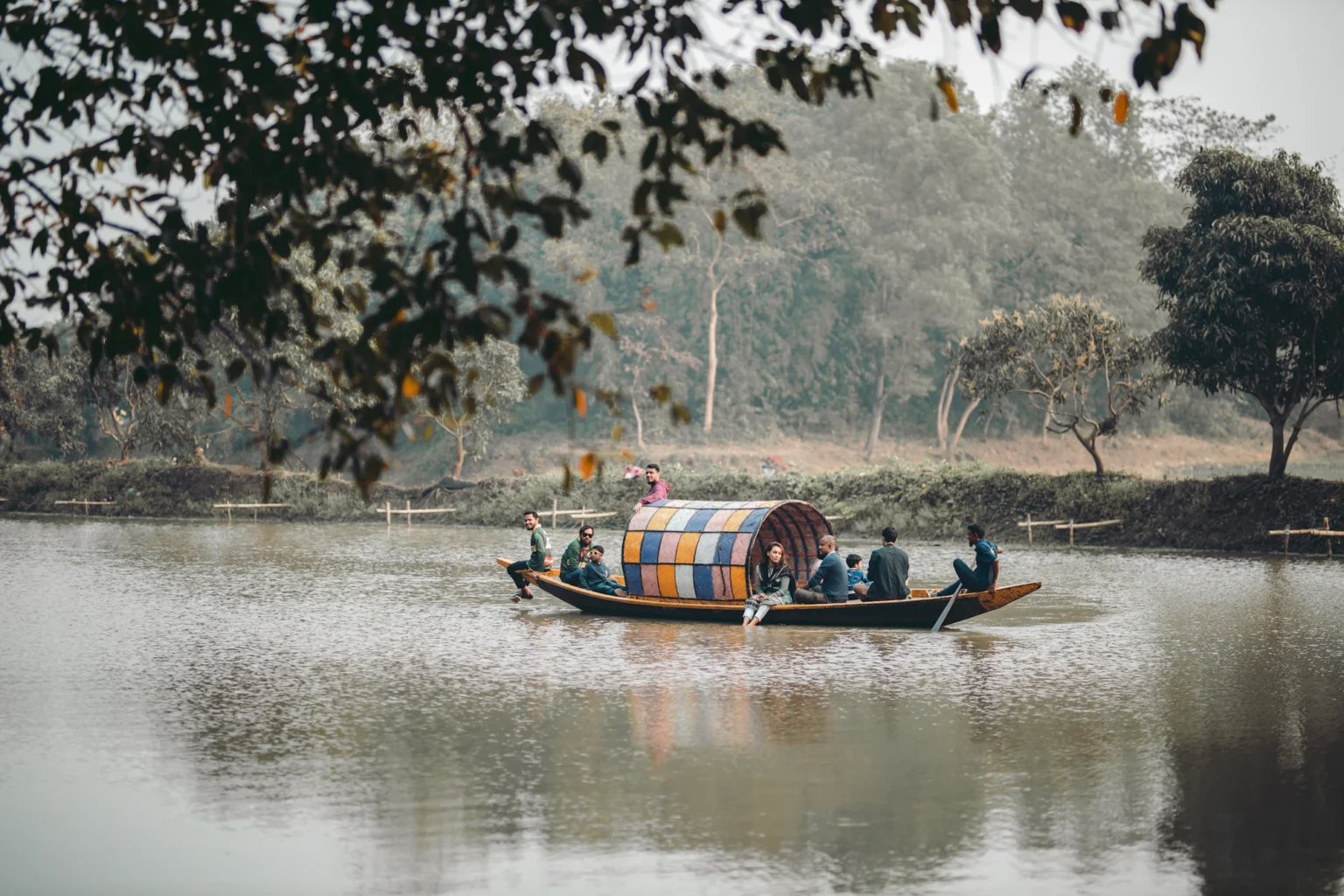 শান্ত নদীতে গাছের নিচে নৌকা