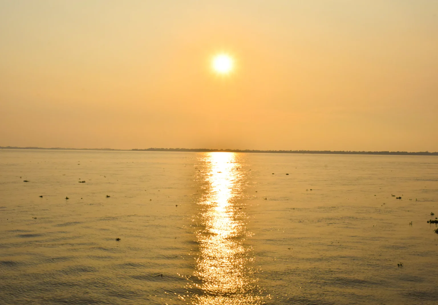 সোনালি সূর্যাস্তে জলের উপর আলোর পথ