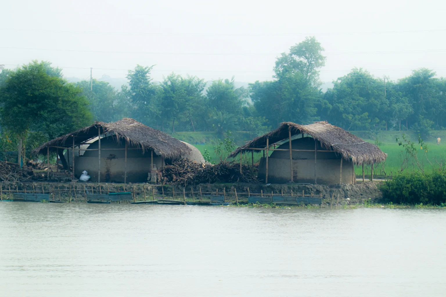 কুয়াশায় ঢাকা জলের ওপর খড়ের ঘর
