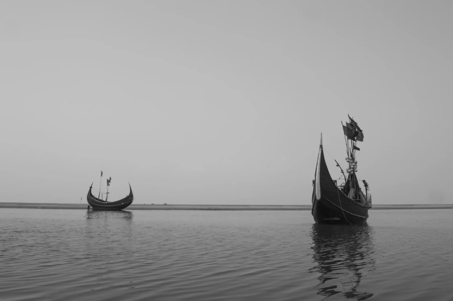 কুয়াশাচ্ছন্ন জলে দুটি নৌকা