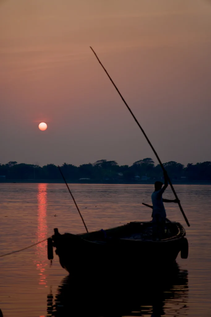 সূর্যাস্তে নদীতে মাঝির ছায়াছবি