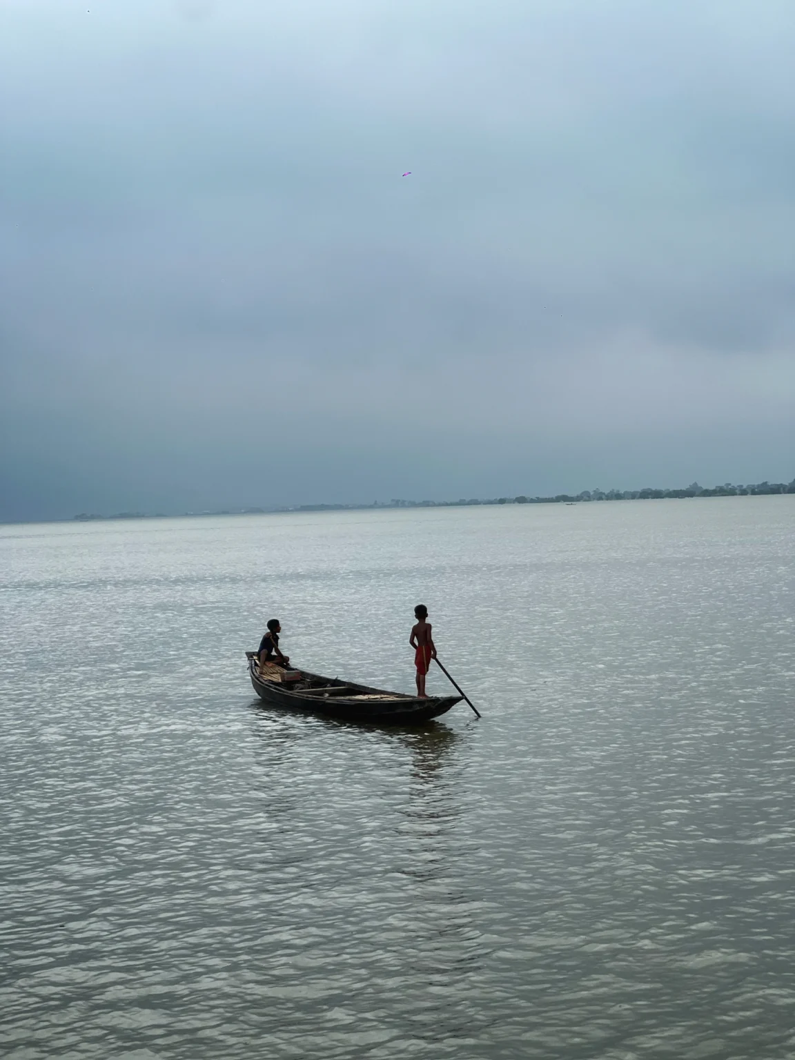 শান্ত জলে ছোট নৌকায় দুইজন মানুষ