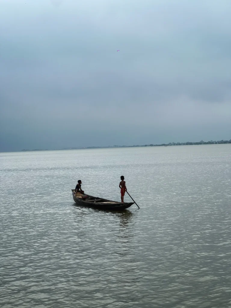শান্ত জলে ছোট নৌকায় দুইজন মানুষ